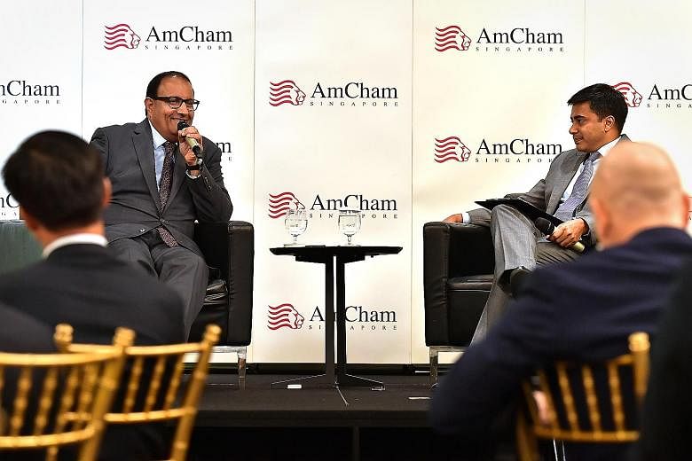 Mr S. Iswaran (far left), with dialogue moderator Kunal Chatterjee, Visa's country manager for Singapore and Brunei, speaking at the American Chamber of Commerce luncheon yesterday. ST PHOTO: NG SOR LUAN