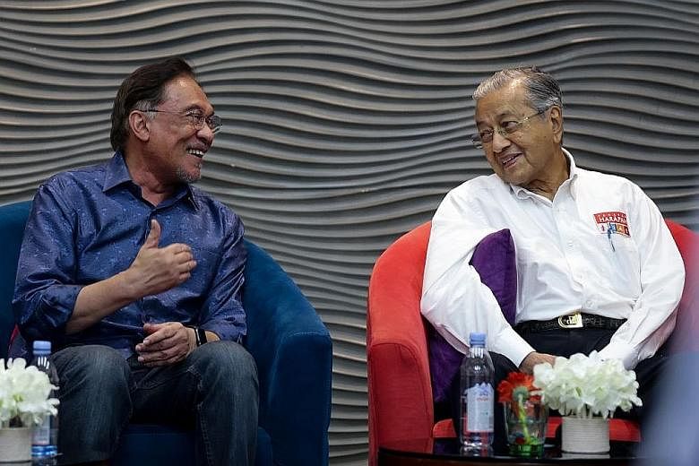 A July 19 photo of Parti Keadilan Rakyat leader Anwar Ibrahim (left) with Prime Minister Mahathir Mohamad at the party's retreat in Port Dickson. Datuk Seri Anwar told Bloomberg there was an understanding he should take power around next May, "but I 