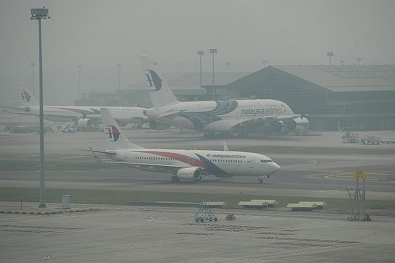 Hazy conditions at Kuala Lumpur International Airport around noon yesterday. Air quality deteriorated to "very unhealthy" levels yesterday on an official index in many parts of Peninsular Malaysia, forcing school closures.