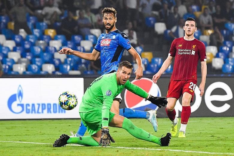 Napoli forward Fernando Llorente (in blue) scoring past Liverpool goalkeeper Adrian during their Champions League clash on Tuesday night. Napoli won the match 2-0 thanks to a penalty and a mistake by Virgil van Dijk which Llorente took advantage of. 