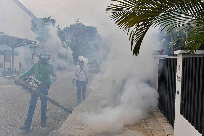 Pest control and National Environment Agency officers carrying out fogging on Sunday in Hemsley Avenue in Serangoon Gardens, where three cases of locally transmitted Zika virus infections were confirmed.