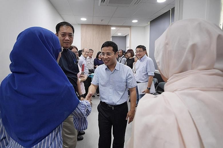 Minister for Social and Family Development Desmond Lee meeting divorce counsellors at the Ang Mo Kio Family Service Centre yesterday. He said judges needed to be empowered further to ensure disputes in divorce cases do not become a zero-sum game. ST 