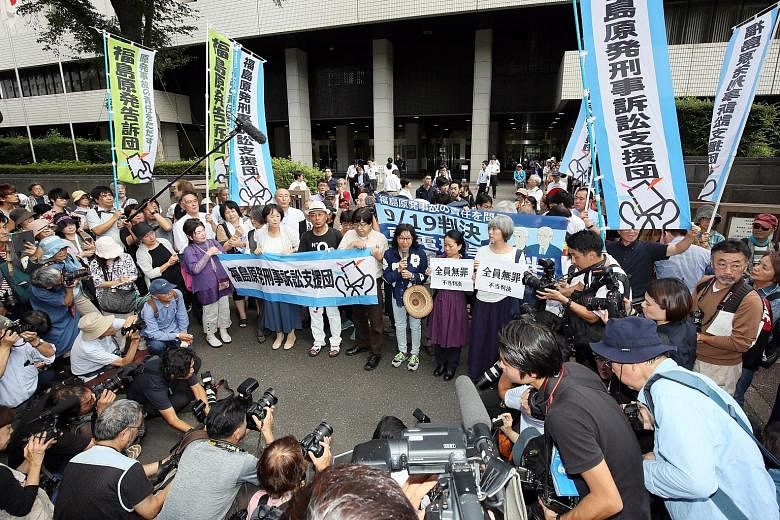 The three former top Tepco executives cleared by the court yesterday are (from left) Sakae Muto, Ichiro Takekuro and Tsunehisa Katsumata. PHOTOS: AGENCE FRANCE-PRESSE Activists rallying outside the Tokyo District Court yesterday as judgment was hande