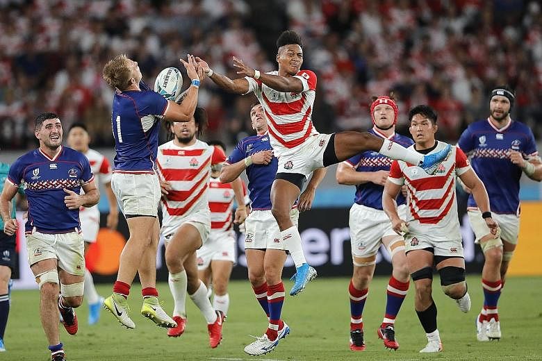 Japan's Kotaro Matsushima (centre) jumping to claim the ball in the Rugby World Cup game against Russia yesterday at Tokyo Stadium. PHOTO: ASSOCIATED PRESS