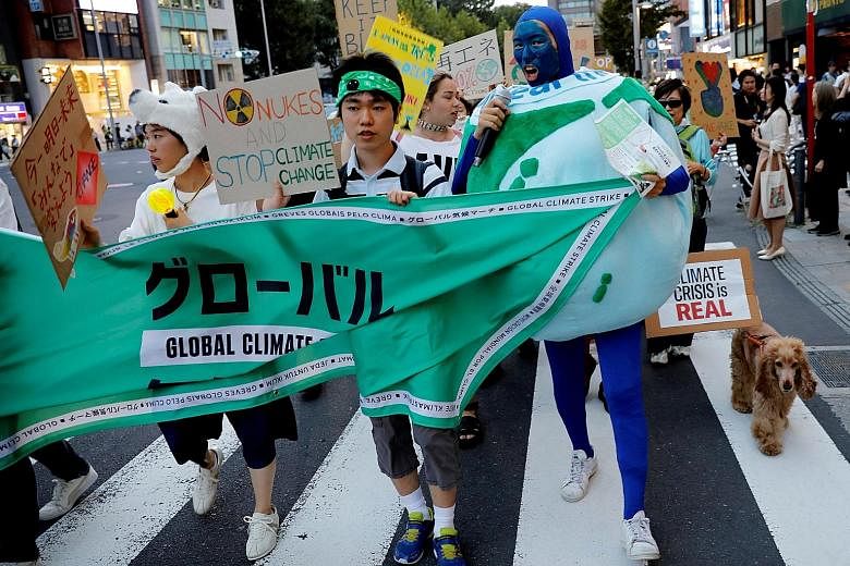 THAILAND: Activists playing dead as part of a demonstration near the Ministry of Natural Resources and Environment's office in Bangkok. JAPAN: Participants marching at an event to mark the day of global climate strikes in Tokyo. AUSTRALIA: Thousands 
