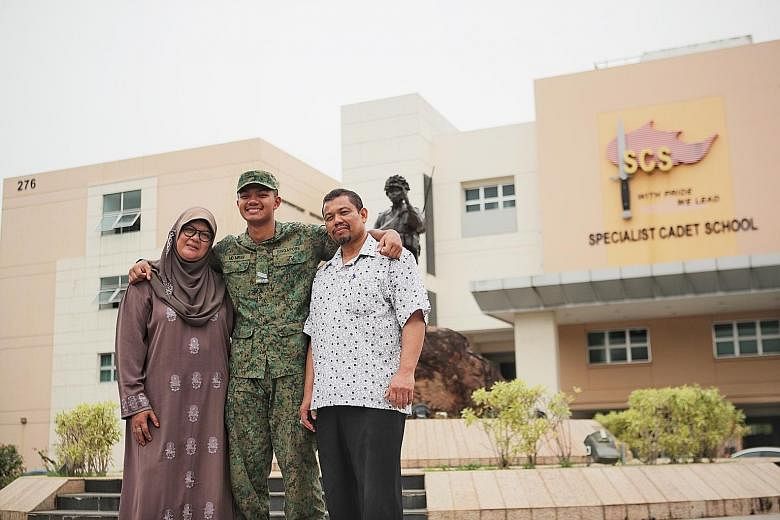 Specialist Cadet Muhammad Imran Azeman with his mother, Madam Rozanah Yassin, and father, Mr Azeman Rahmat, at Pasir Laba Camp yesterday. A photo of him (below) receiving a rifle with his muscular arms from his platoon commander during basic military