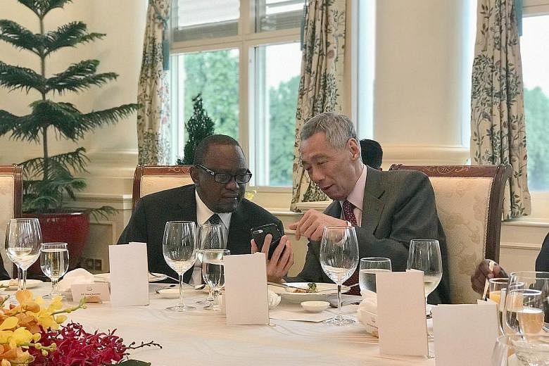 PM Lee showing Kenyan President Uhuru Kenyatta the SingPass app and how it is used to access government e-services. Japan's Liberal Democratic Party policy research council chairman Fumio Kishida with Prime Minister Lee Hsien Loong yesterday.