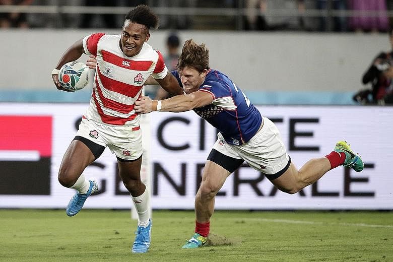 Japan's Kotaro Matsushima fending off Russia's Vladislav Sozonov to score his third try in the Rugby World Cup Pool A game at Tokyo Stadium last night. The utility back is the first player to score three tries in a World Cup opener. 