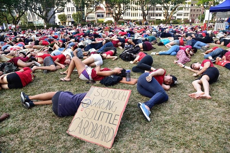 Participants lying on the grass in a "die-in" at Hong Lim Park yesterday as they called for more action to reduce planet-warming emissions. One of the rally organisers said participants were urged to turn up in red to signal that climate change is no