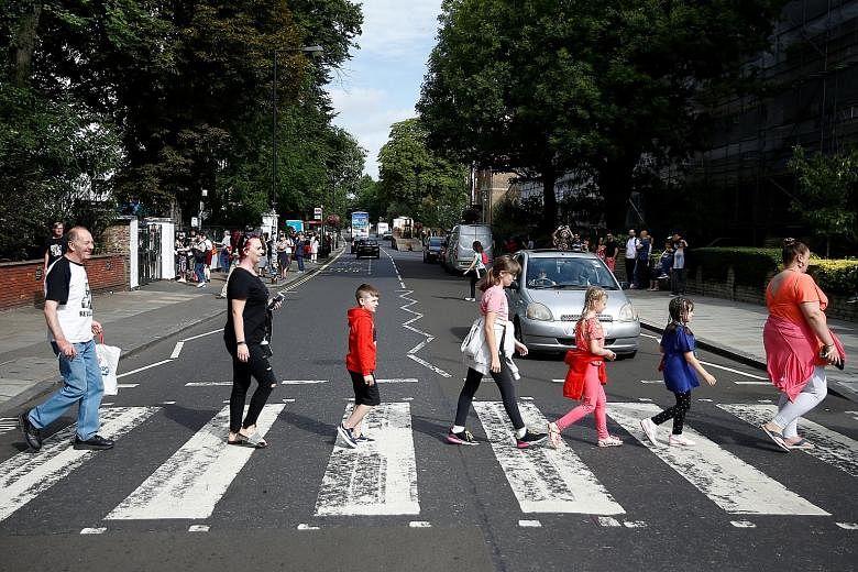 The now-iconic photograph of The Beatles crossing Abbey Road is a scene which fans try to recreate when they are in London (above). 