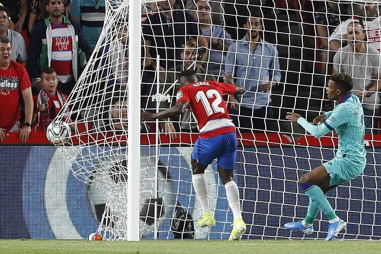 Granada's Ramon Azeez (No. 12) heading home the opening goal against Barcelona in just the second minute, as defender Nelson Semedo can only watch on helplessly. 