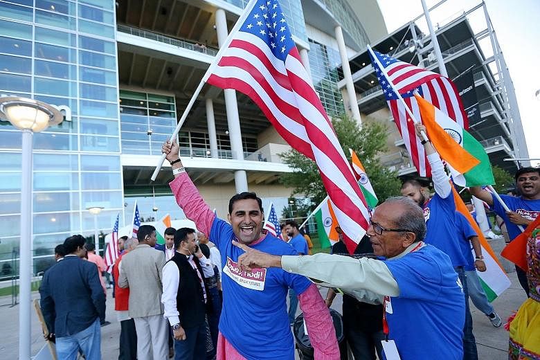 Jubilant supporters waving flags before the start of a rally yesterday in support of visiting Indian Prime Minister Narendra Modi at a stadium in Houston, Texas. The event gave Mr Modi, who was joined by US President Donald Trump, a chance to energis