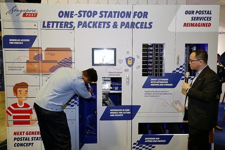 A postman putting mail into the central deposit of SingPost's smart letterbox prototype, with Mr Edmund Tan, SingPost's vice-president of innovation for postal services, explaining how the machine scans data matrix codes and then sorts mail into stor