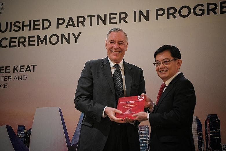 Applied Materials chief executive and president Gary Dickerson receiving the Distinguished Partner in Progress Award on behalf of the US firm from Deputy Prime Minister Heng Swee Keat yesterday. ST PHOTO: MARK CHEONG