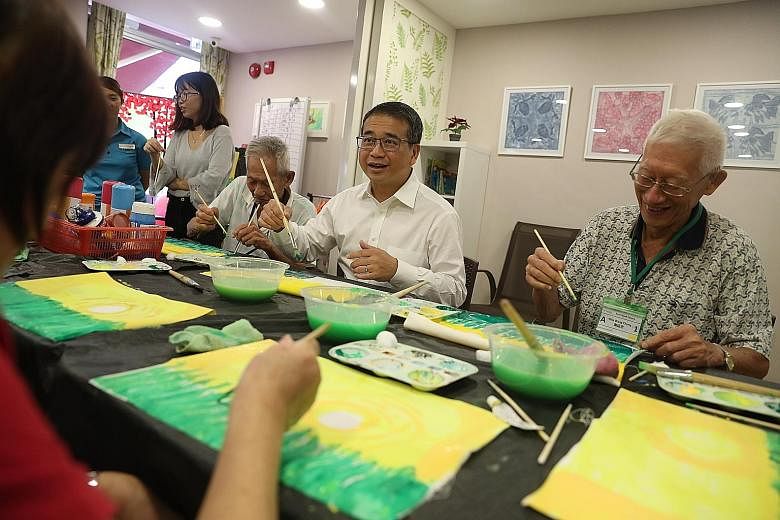 Senior Minister of State for Health Edwin Tong joining in a painting session at St Luke's ElderCare in Pandan Gardens yesterday. Besides financial help, caregivers now have access to the Go Respite pilot, which cuts waiting time for senior care centr