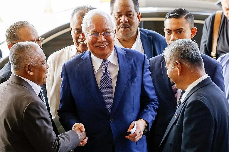 Malaysia's former premier Najib Razak is greeted by his supporters at the High Court in Kuala Lumpur, Malaysia, yesterday. He faces four charges of using his position to obtain bribes totalling RM2.3 billion (S$760 million) from 1MDB funds. PHOTO: EP