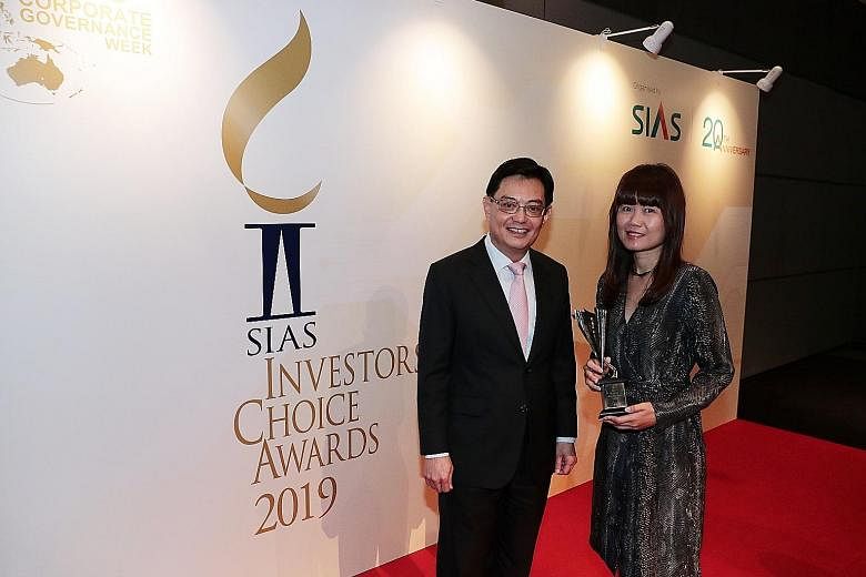 The Business Times' senior correspondent Angela Tan with Mr Ong Cheong Tee, deputy managing director of financial supervision at the Monetary Authority of Singapore, and Mr David Gerald, president and chief executive of the Securities Investors Assoc
