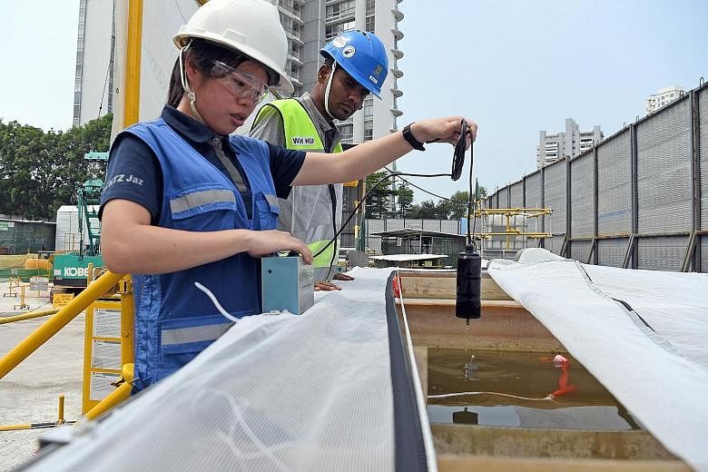 A larvasonic system - which generates soundwaves to cause mosquito larvae to rupture - being deployed at a waste water treatment tank at the worksite of the upcoming Tanjong Katong MRT station yesterday. ST PHOTOS: DESMOND FOO