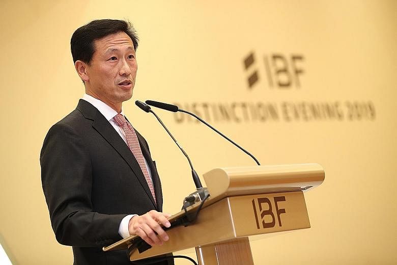 Above: OCBC Bank's consumer financial services head Dennis Tan was one of five recipients of the IBF Distinguished Fellow Award yesterday. Left: Education Minister Ong Ye Kung, speaking at the IBF's gala dinner yesterday, encouraged finance professio