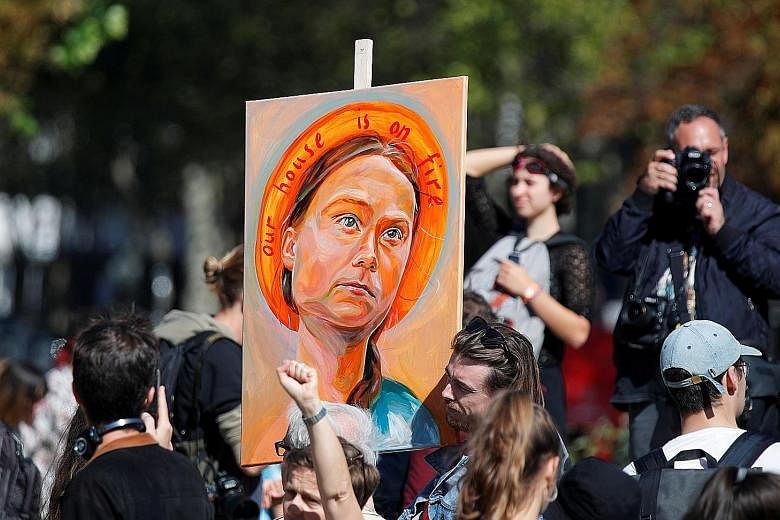 A demonstrator with a poster depicting Swedish climate activist Greta Thunberg at a climate change protest in Paris two Fridays ago. PHOTO: REUTERS Students in the Global Climate Strike march in New York on Sept 20. The message of teen activists is t