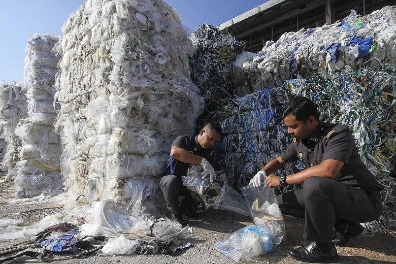 Malaysian Customs officers taking samples of plastic waste from one of the containers at Port Klang.