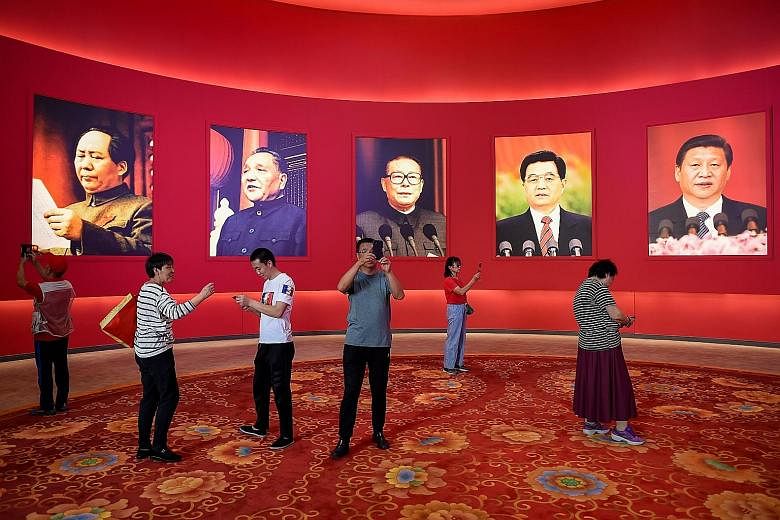 Visitors at a Beijing exhibition marking the country's achievements on Thursday, ahead of the 70th anniversary of the founding of the People's Republic of China on Oct 1. On display were portraits of (from left) past Chinese leaders Mao Zedong, Deng 