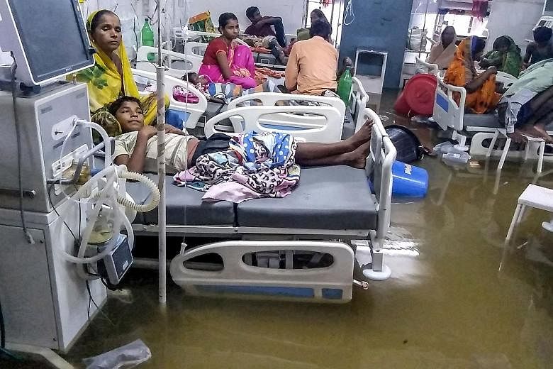 Patients and their relatives waiting out the floods at the waterlogged Nalanda Medical College and Hospital in Patna, in India's north-eastern state of Bihar, yesterday. 