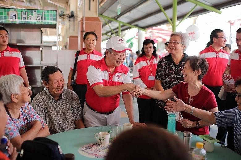 Progress Singapore Party secretary-general Tan Cheng Bock greeting people at Ghim Moh Market and Food Centre yesterday. About 300 party members and volunteers visited all 29 constituencies across the island.