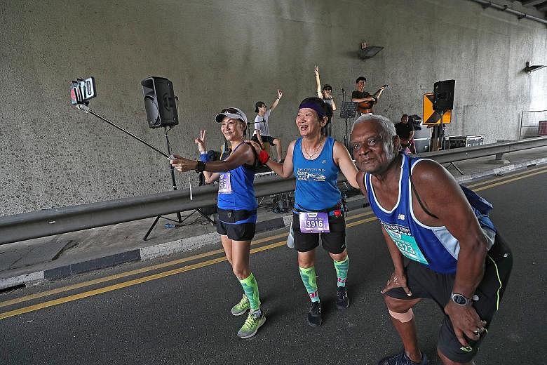 From left: Jessie Chong, 58, Merry Hui, 60 and G. Ramanatham, 80, having fun at the entertainment point near Crawford Street during their 10km event as folk and pop band The SlaCks perform.