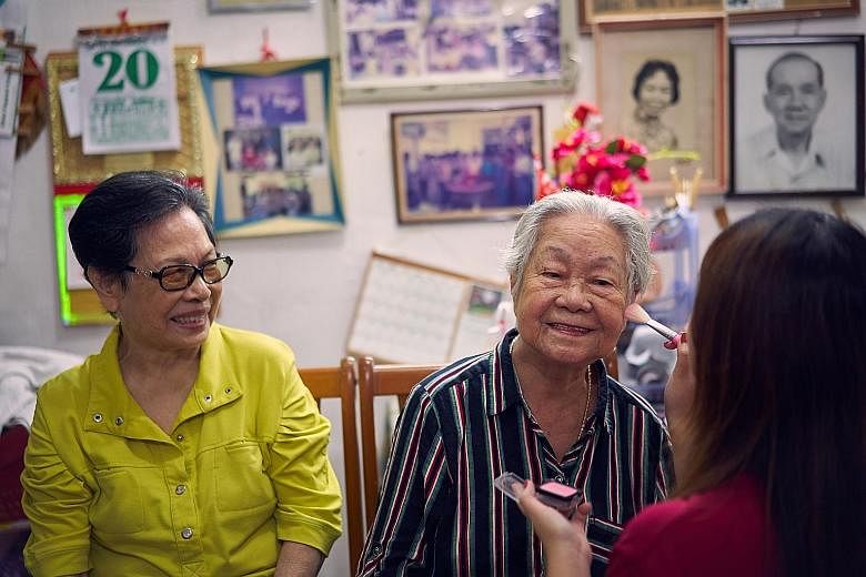 Madam Tan and Madam Poon visiting Clifford Pier, accompanied by staff from the Home Nursing Foundation. ST PHOTO: KEVIN LIM Madam Tan Bock Eng (left), 80, watching as Madam Poon Soo Lan, 86, got her make-up done by a volunteer from the Home Nursing F