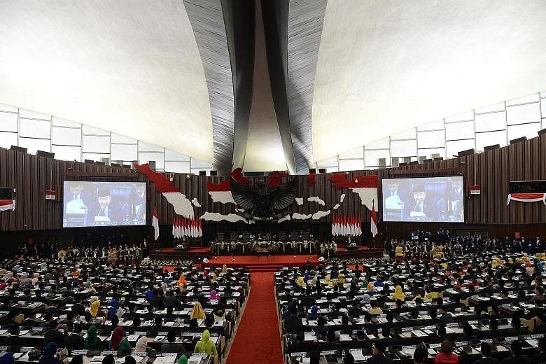 Indonesian lawmakers were sworn in yesterday at the heavily barricaded Parliament building in Jakarta. The ceremony was witnessed by President Joko Widodo and other top officials. PHOTO: AGENCE FRANCE-PRESSE