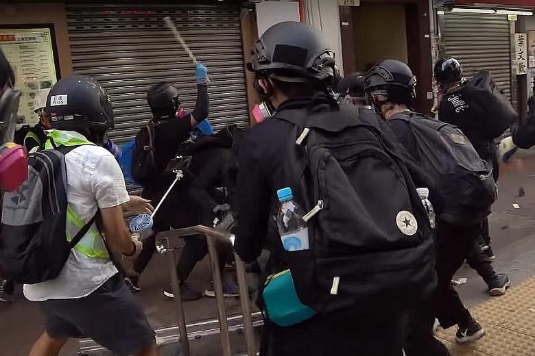 Screenshots from a video showing the sequence of events during clashes in Tsuen Wan, Hong Kong, on Tuesday. From top: The 18-year-old protester dressed in black (centre, holding up pole) attacks a police officer. Another officer then shoots the teena