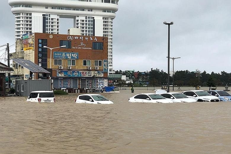 Vehicles left submerged in Gangneung, Gangwon-do province, after Typhoon Mitag brought heavy rain and floods to South Korea yesterday. More than 1,000 homes were damaged and over 1,500 people evacuated their houses in advance, the Ministry of Interio
