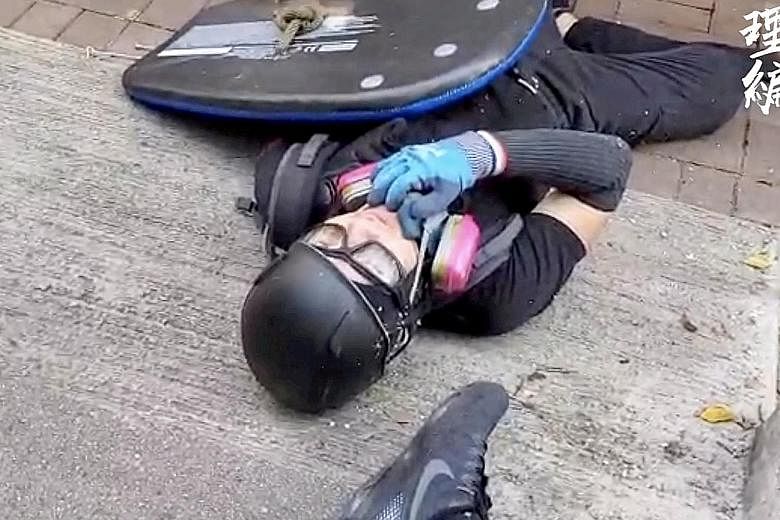 Student Tsang Chi Kin lying on the ground after he was shot. He has been hailed as a hero and derided as a thug in less than 24 hours after the incident. PHOTO: REUTERS