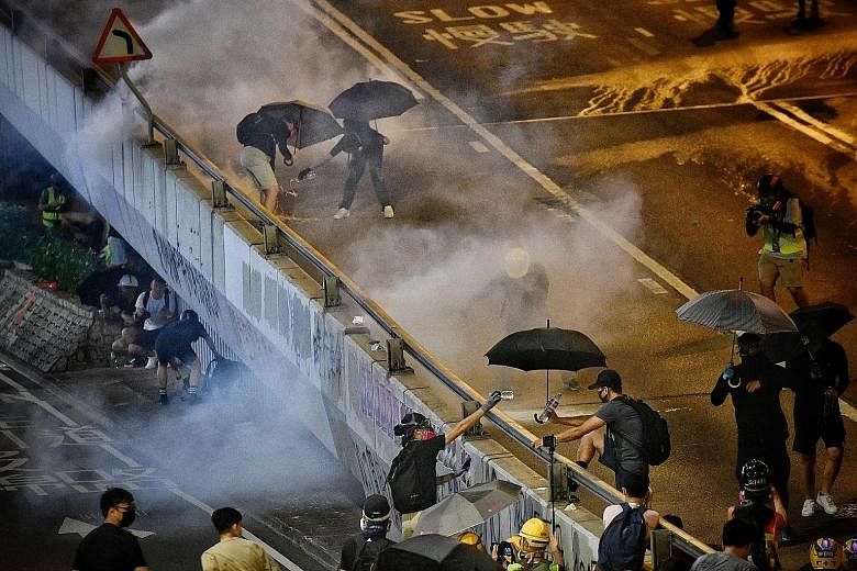 Police covering the mouth of a protester they arrested to stop him from speaking to the media in Harcourt Road on Sept 29. Clashes between protesters and police have led to unbridled anger against what was once known as Asia's finest force. Protester