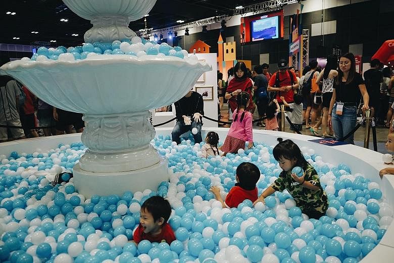 Children playing in a mini replica of Rome's Trevi Fountain during Klook's inaugural travel fair at Suntec convention centre yesterday. Besides access to exclusive Klook promotional codes, visitors can also look forward to flash deals, such as one-fo