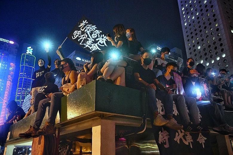 Above, left: Protesters on the roof of a carpark next to Edinburgh Place in Hong Kong on Sept 27. Left: Protesters tearing off decorations marking the 70th anniversary of the People's Republic of China on an overhead bridge connecting Pacific Plaza a