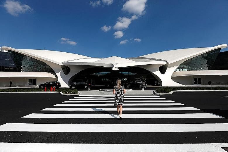 A traveller approaches the TWA Hotel inside New York's John F. Kennedy International Airport. The recently opened hotel was once Trans World Airlines' terminal. It was built in 1962 as an uplifting symbol of the Jet Age and was designed by renowned F