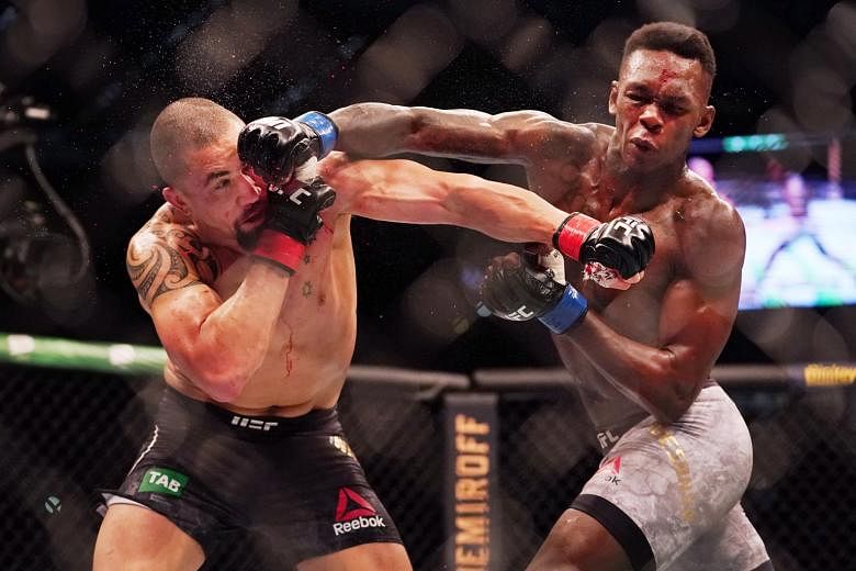 Kiwi Israel Adesanya landing a punch on Australian Robert Whittaker during UFC 243 in Melbourne yesterday. Adesanya captured the middleweight title after a second-round knockout for his sixth win from six fights in the last 14 months. 