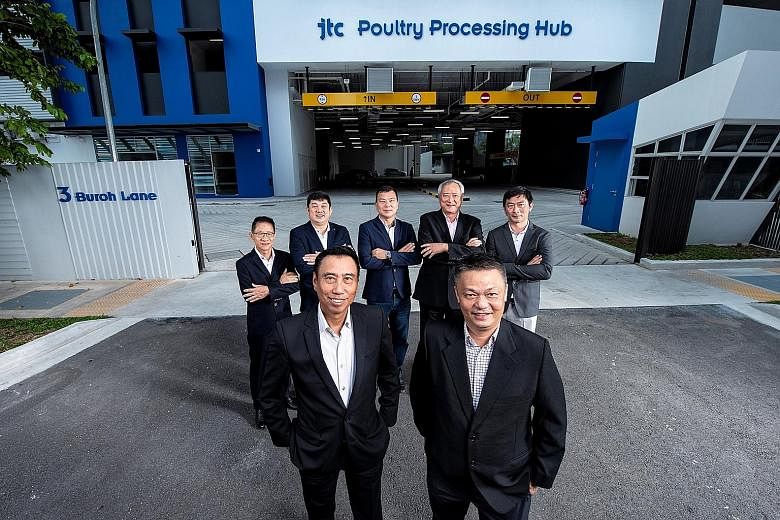 United Overseas Bank (UOB) head of group commercial banking Eric Tham (left) and Singapore Poultry Hub CEO Joseph Heng with the hub's five shareholders at JTC Poultry Processing Hub @ Buroh. UOB will be furnishing a $40 million loan for the upcoming 