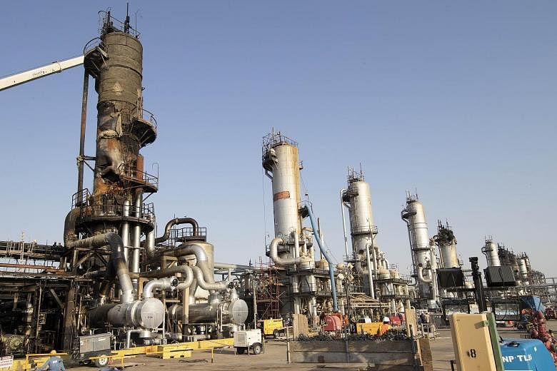 A damaged refining tower (above, left) at Saudi Aramco's Abqaiq crude oil processing plant following a drone attack last month. The pre-dawn attack in Saudi Arabia knocked out more than half of the top global exporter's output: 5 per cent of the worl