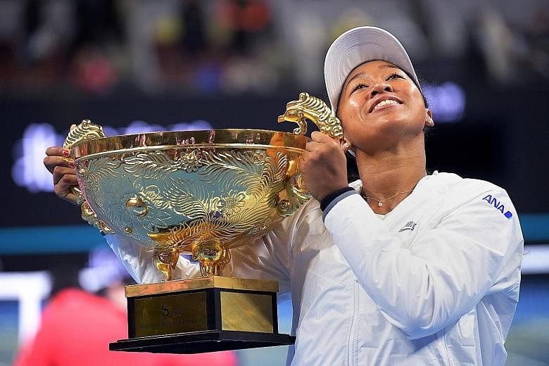 Naomi Osaka hoisting the trophy from the China Open, her second straight title, having won last month's Pan Pacific Open.