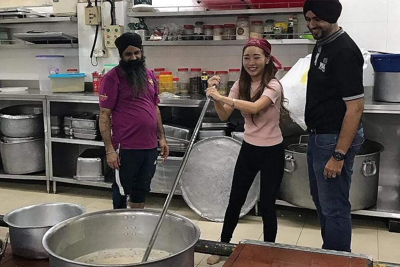 Social media influencer Sheena Phua with Young Sikh Association (YSA) president Sarabjeet Singh (at right) and a volunteer at the Central Sikh Temple. Law and Home Affairs Minister K. Shanmugam cited the association's reaching out to Ms Phua as an ex