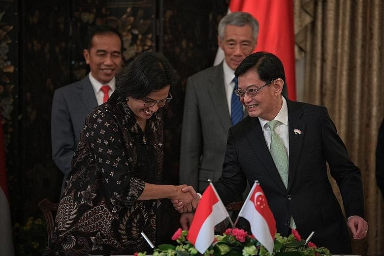 Finance Minister Heng Swee Keat, who is also Deputy Prime Minister, and his Indonesian counterpart Sri Mulyani Indrawati after signing a pact yesterday on the electronic exchange of trade data between their countries. The signing was witnessed by Ind