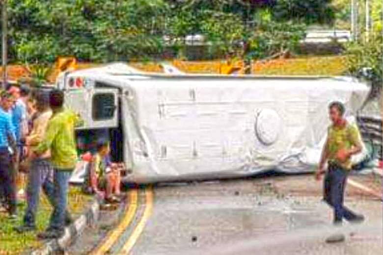 The minibus was lying on its side across the width of the Eng Neo Avenue slip road after the accident on Monday. The roof of the bus was dented, and one of its back doors had opened.