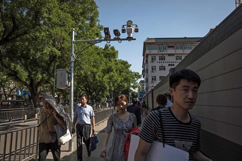 Surveillance cameras on a street in Beijing. Chinese firms on the US trade blacklist include video surveillance firm Hikvision, which said it "strongly opposes" the US decision to widen the list. PHOTO: EPA-EFE Left: A still from a video posted anony