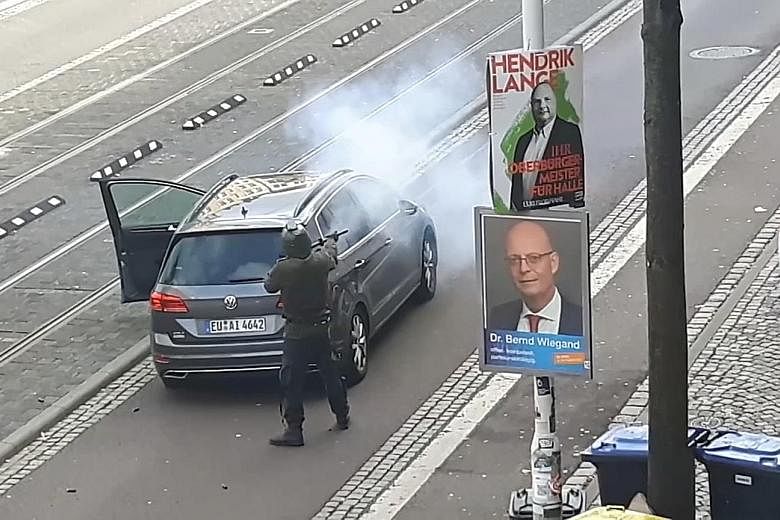 Footage from an amateur video showing the shooter firing at a car in the German city of Halle. One of the assailants was arrested, while two others remain at large.