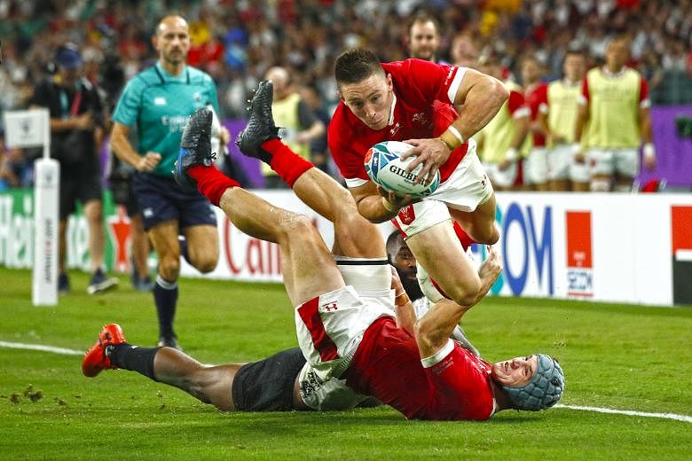 Josh Adams crossing the line to score his third try in Wales' 29-17 win over Fiji in Pool D at the Oita Stadium yesterday. The bonus-point win booked Wales their last-eight ticket. PHOTO: REUTERS