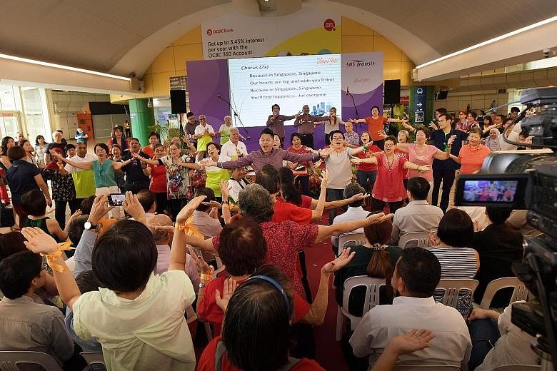 SBS Transit staff leading senior citizens in a dance session during the launch of The Magic Cares Van community programme. The programme, which aims to engage seniors and others with limited mobility, features touch-free music devices that use sensor