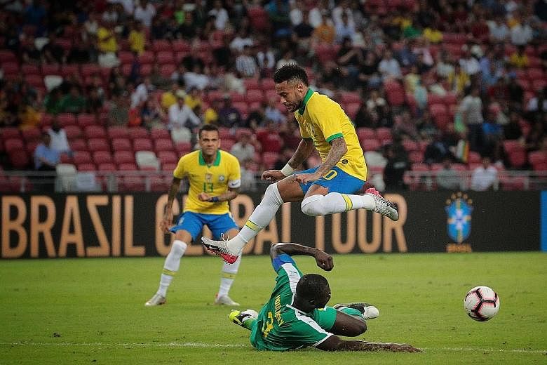 Above: A joyous Famara Diedhiou after converting a penalty to equalise for the African side. Left: Neymar evading a tackle by Senegal's Kalidou Koulibaly in last night's international friendly at the National Stadium. The Brazil star notched his cent